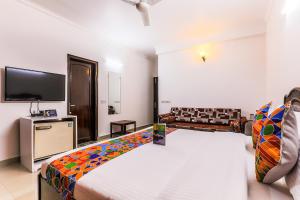 a large room with a bed and a tv at FabExpress Hemkunt Mansion in Noida