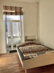a bed in a room with a large window at Modern 2-room flat in the city center in Šiauliai