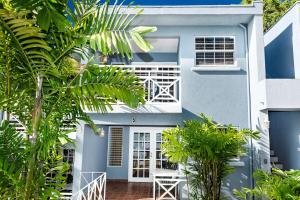 a blue house with palm trees in front of it at The Palms Resort in Saint James