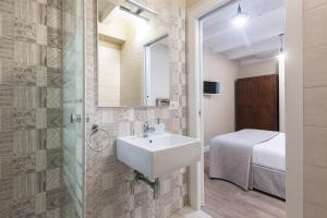 uma casa de banho com um lavatório e um chuveiro em White House em Cagliari