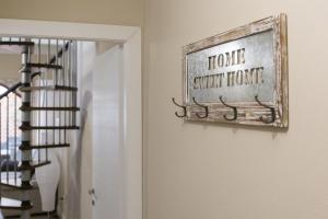 a sign that reads home sweet home next to a staircase at White House in Cagliari