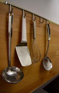 a group of kitchen utensils hanging on a wall at Frühstückspension Pachler in Gosau