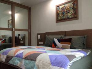 a bedroom with a bed with a colorful quilt on it at Studio room Nagoya Mansion View Swimming Pool in Nagoya