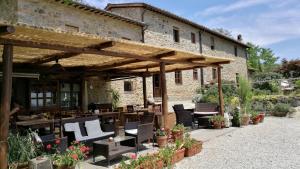 un pavillon avec des chaises et des tables en face d'un bâtiment dans l'établissement Agriturismo La Fagianaia, à Borgo a Buggiano