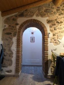 um arco numa sala com uma parede de pedra em Casa nel Borgo - Il Gufo em Tremosine Sul Garda