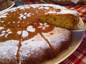 a cake with powdered sugar on a plate on a table at Pousada Kolibri in São Francisco Xavier