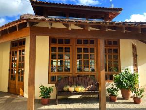 a bench in front of a building with a roof at Pousada Kolibri in São Francisco Xavier