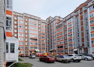 トムスクにあるДвухкомнатные апартаменты Советская 69の高層ビルの前に車を駐車した駐車場