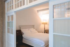 北港鎮的住宿－暗街宅內民宿，卧室配有带白色床单的双层床