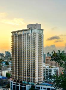 a tall building in a city at sunset at Barry Boutique Hotel Sanya in Sanya