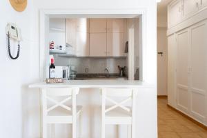 a kitchen with white cabinets and a counter with stools at Frontline Beach Apartment in San Andrés