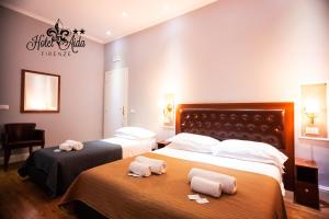 2 letti in camera d'albergo con asciugamani di Hotel Aida a Firenze
