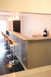 a bar in a restaurant with a row of stools at Eden Guesthouse B&B in Dana Bay