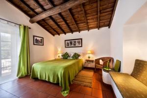 een slaapkamer met een groen bed in een kamer bij Monte do Serrado De Baixo in Évora