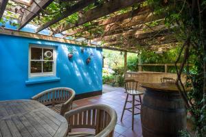 een patio met een tafel en stoelen en een blauwe muur bij Trengilly Wartha Inn in Constantine