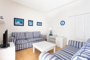 uma sala de estar com dois sofás e uma televisão em Frontline Beach Apartment em San Andrés