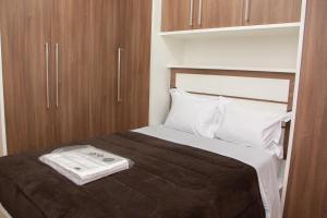 a bedroom with a large bed with wooden cabinets at Caparaó Casa Feliz in Alto Caparao
