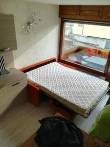 サン・マルティーノ・ディ・カストロッツァにあるVilla Neveの窓付きの小さな部屋のベッド1台分です。