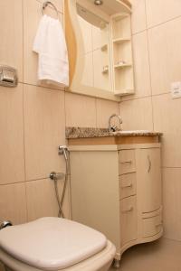 a bathroom with a toilet and a sink and a mirror at Caparaó Casa Feliz in Alto Caparao