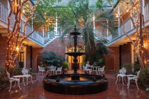 een grote fontein in het arium met tafels en stoelen bij Hotel Provincial in New Orleans