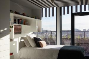 a bedroom with a bed and a large window at Birdcage Penthouse Luxury Melbourne Ultra Modern Industrial Chic in Melbourne