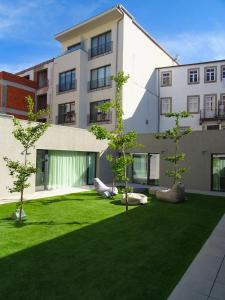 un edificio de apartamentos con césped delante en I Loft Porto, en Oporto