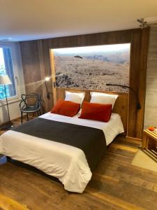 1 dormitorio con 1 cama grande y 2 almohadas rojas en Hôtel LAPIAZ & Spa - FLAINE, en Flaine