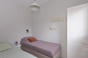 a white bedroom with two beds and a closet at Banjaard Beachhouse Patrijzenlaan 16 in Kamperland
