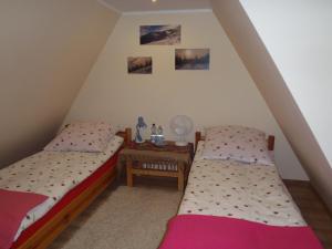 two twin beds in a room with a table at Kraina Szczęśliwości in Zawoja