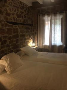 a bedroom with two beds and a brick wall at LA RAMA DEL CASTOR in Espinama