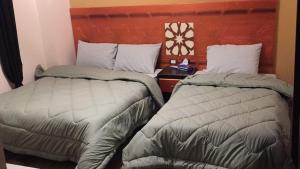 dwa łóżka siedzące obok siebie w pokoju w obiekcie H100 Pyramids View w mieście Giza