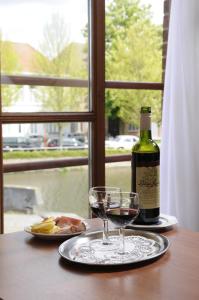 einen Tisch mit einer Flasche Wein und zwei Gläsern in der Unterkunft Rosenburg Hotel Brugge in Brügge