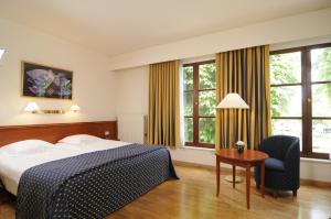 Habitación de hotel con cama, mesa y sillas en Rosenburg Hotel Brugge en Brujas