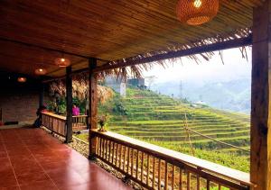 une terrasse couverte avec vue sur une rizière dans l'établissement Sapa Hmong Bungalow Homestay, à Sa Pa