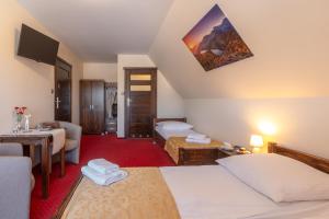 a hotel room with two beds and a table at Willa Skalny Potok 605-077-100 in Zakopane