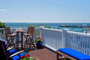 a balcony with two chairs and a table with a view of the water at Benchmark Inn in Provincetown