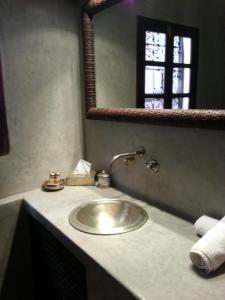 a bathroom with a sink and a mirror at Riad Azza in Marrakesh