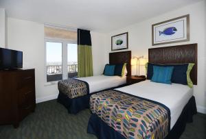 a hotel room with two beds and a television at Atlantic Terrace in Daytona Beach Shores