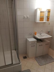 a bathroom with a shower and a sink and a tub at Haus Bergsicht in Imsterberg
