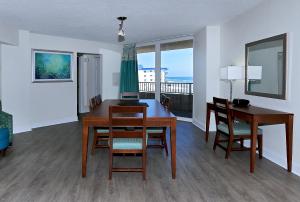 a dining room with a table and chairs and a balcony at Atlantic Terrace in Daytona Beach Shores