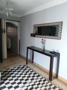 a living room with a table and a mirror at Riad Azza in Marrakesh