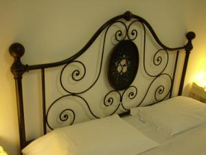 a bed with a black and white headboard and white sheets at Verena Dependance Savoia & Campana in Montecatini Terme