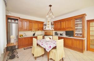 a kitchen with a table with chairs in it at Raffinato attico vicino al mare con solarium Lido di Camaiore in Camaiore