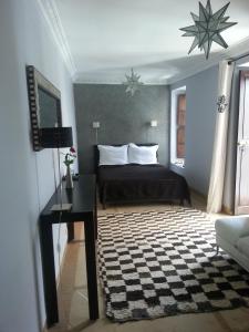 sypialnia z łóżkiem, biurkiem i telewizorem w obiekcie Riad Azza w Marakeszu