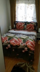 een bed met rode rozen voor een raam bij Honey rooms Hunedoara in Hunedoara