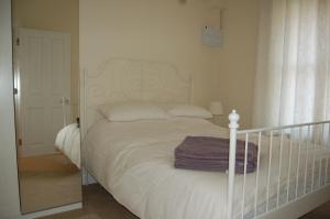 a white bed in a bedroom with a mirror at 3 Endless Street in Salisbury