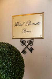 a sign on a wall with a pair of scissors at Hotel Barrett in Rome