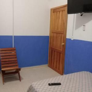a bedroom with a bed and a wooden door at Hotel Chaac Calakmul in Xpujil