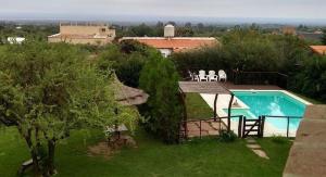 a house with a swimming pool in a yard at Barranca Del Indio in Merlo