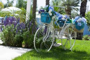 Deux vélos avec des fleurs assises dans l'herbe dans l'établissement B&B Villa Eraclea, à Villaggio Mosè